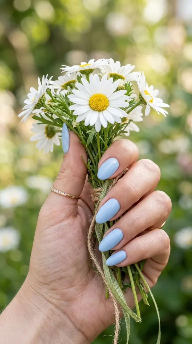 Close-up of manicured hand with baby blue polish on almond-shaped nails