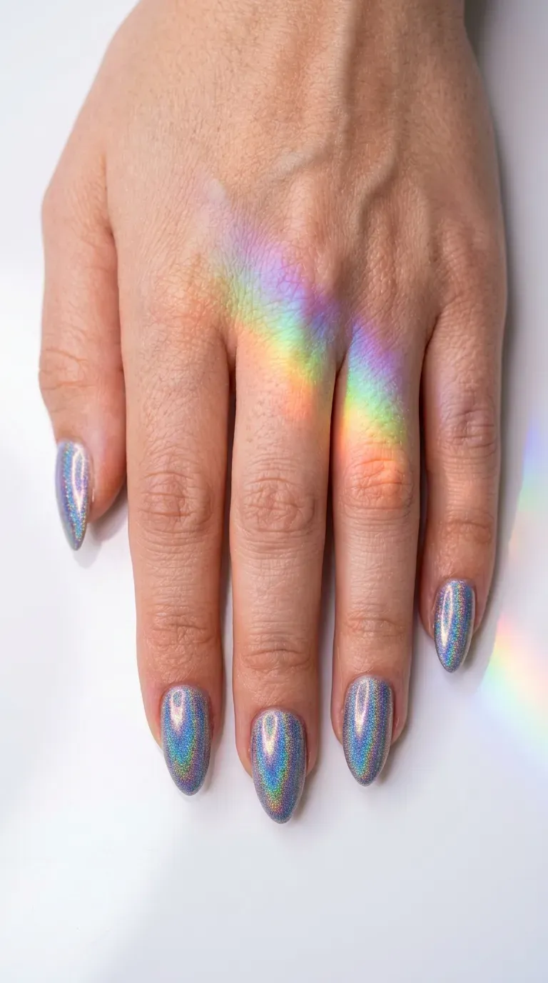 Close-up of manicured hand with holographic finish mermaid nails reflecting rainbow light